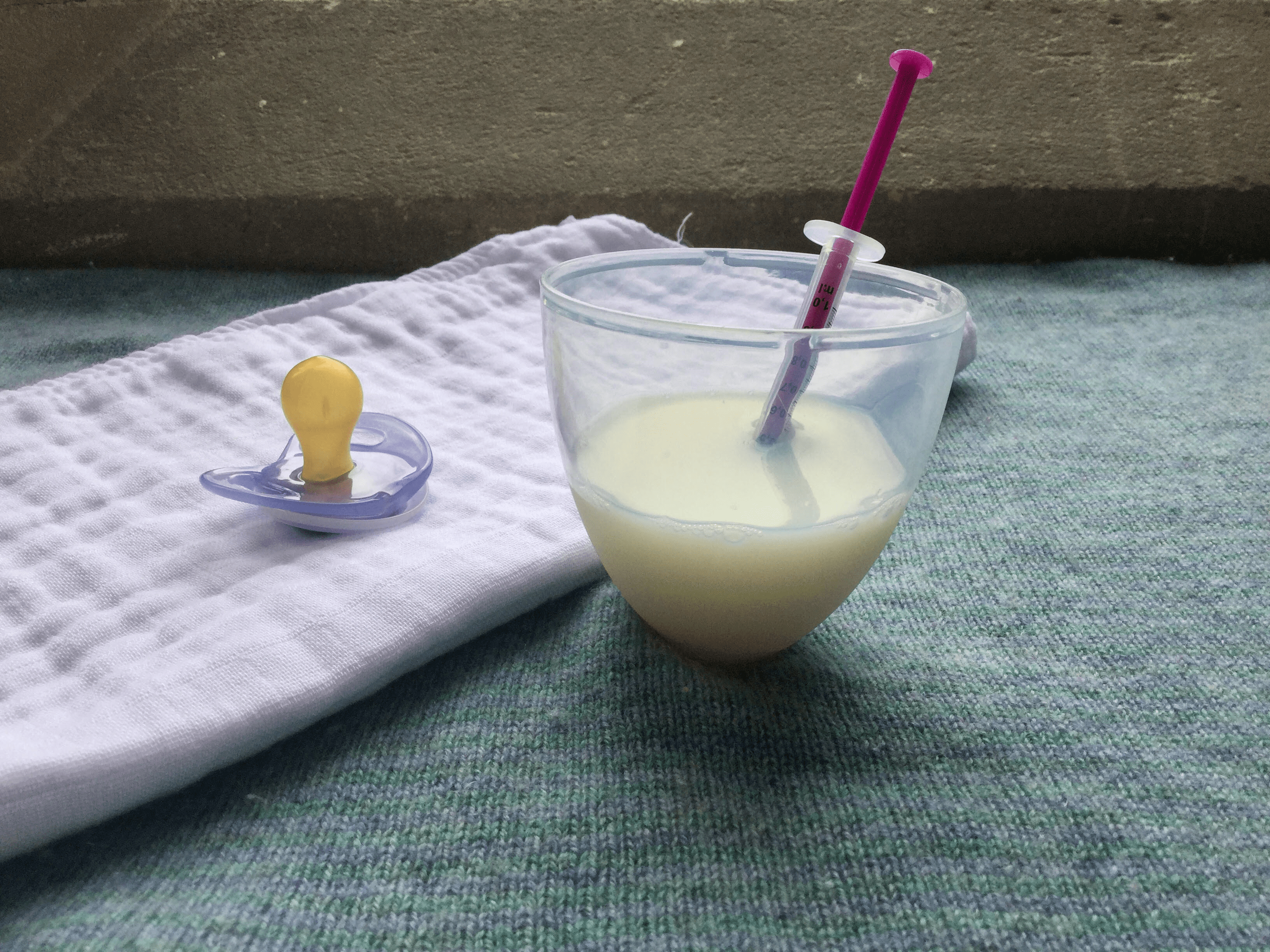 Muslin square, milk, syringe and pacifier