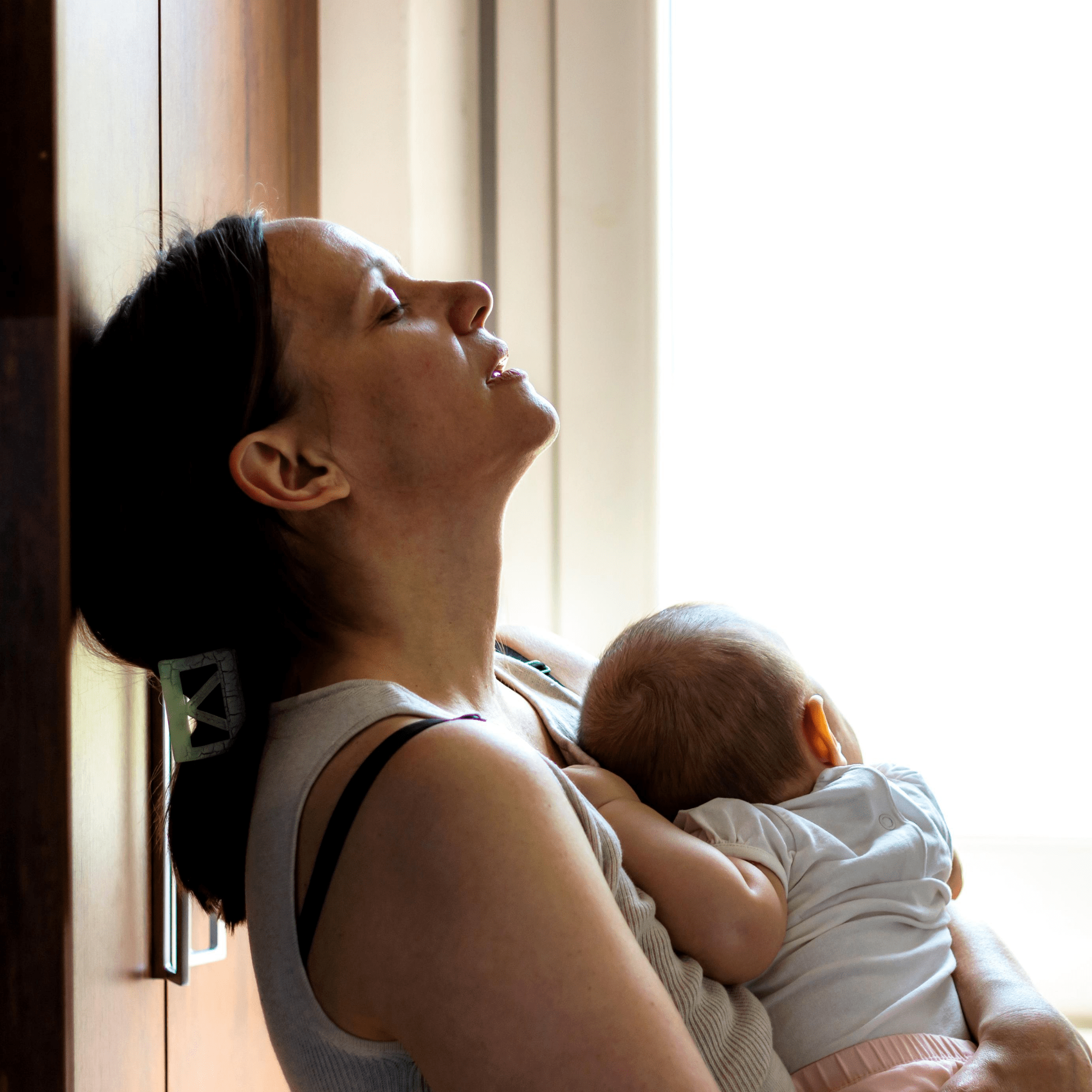 tired woman holding baby