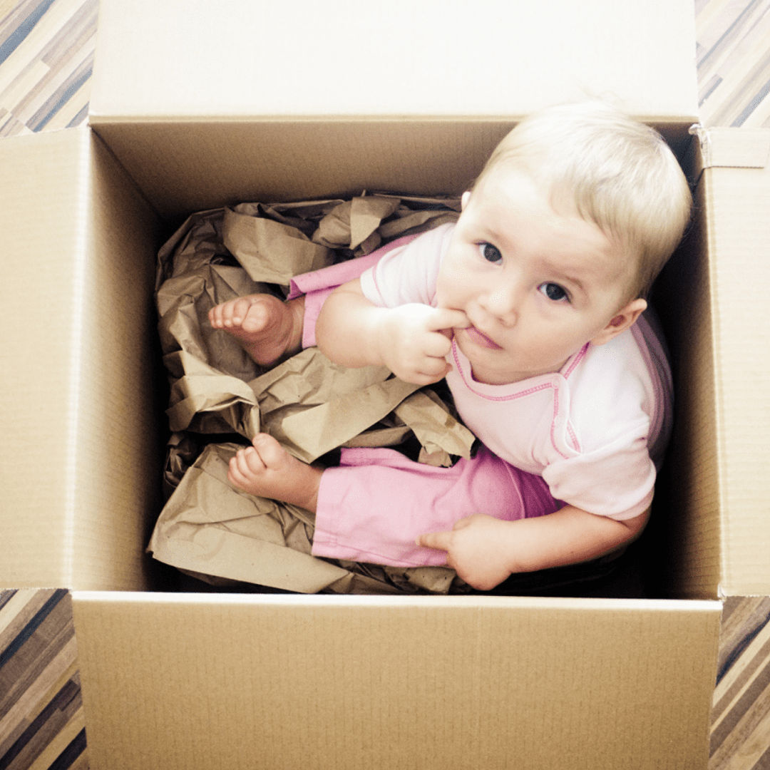 8 month old baby sitting in box to represent the limitations of current parenting methods.